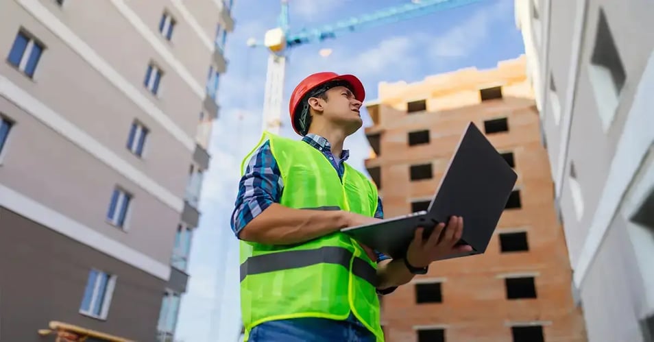 image of a construction professional using a laptop on a jobsite