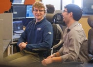 Two coworkers laughing at computer