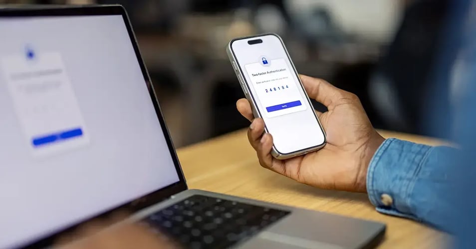 an image of a person receiving a two factor authentication code to his phone from his laptop