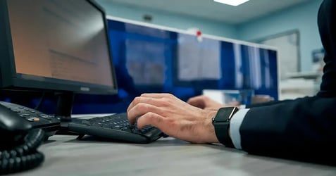 an image of an employee accessing data on his desktop computer in a cubicle office setting