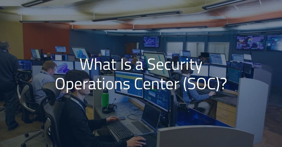 Cybersecurity analysts monitoring threat data at workstations in a security operations center.