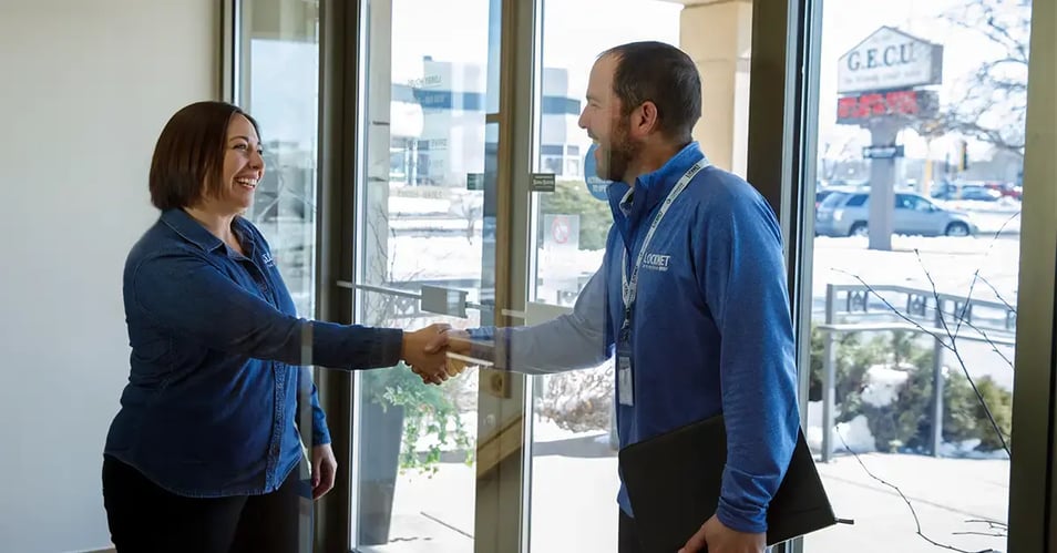 Locknet team member shaking hands with a credit union employee, representing managed security services for financial institutions.