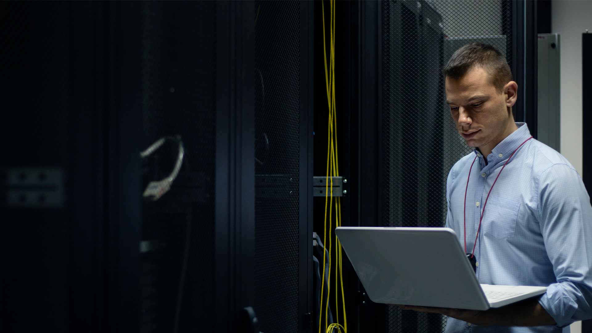 network_specialist_in_server_room_looking_at_laptop