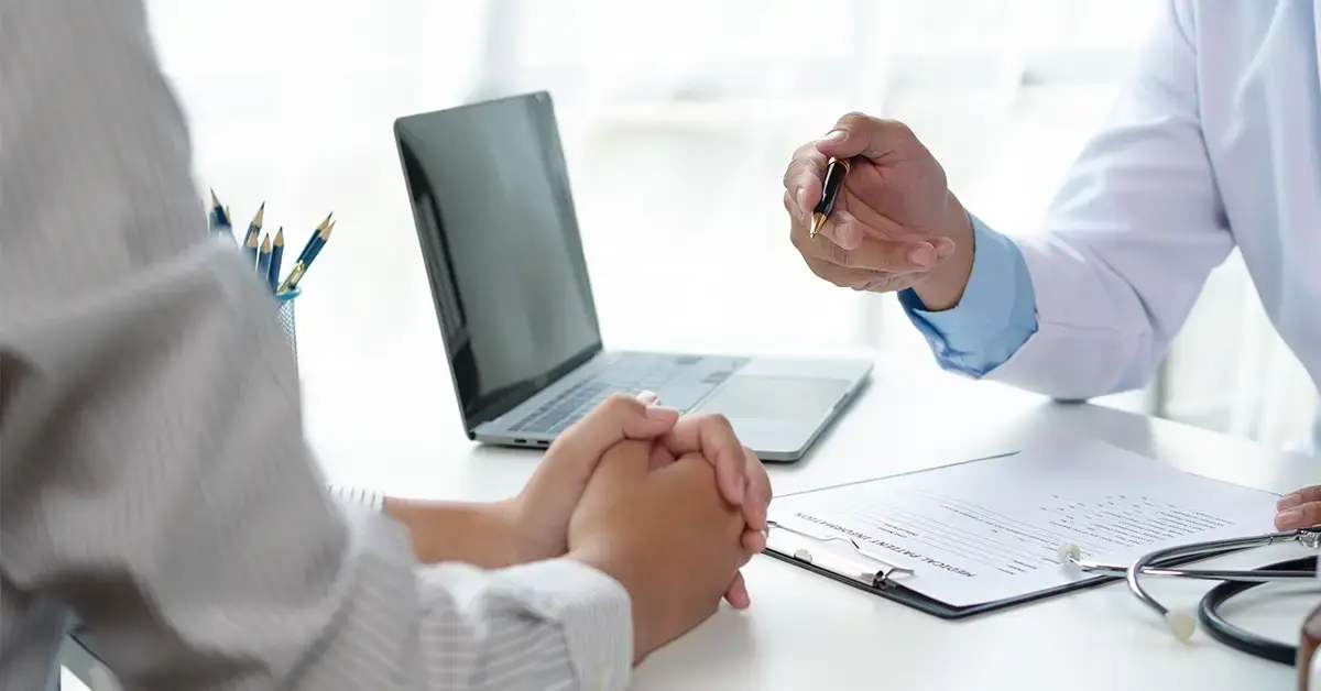 image of a medical professional discussing HIPAA protected information with his patient
