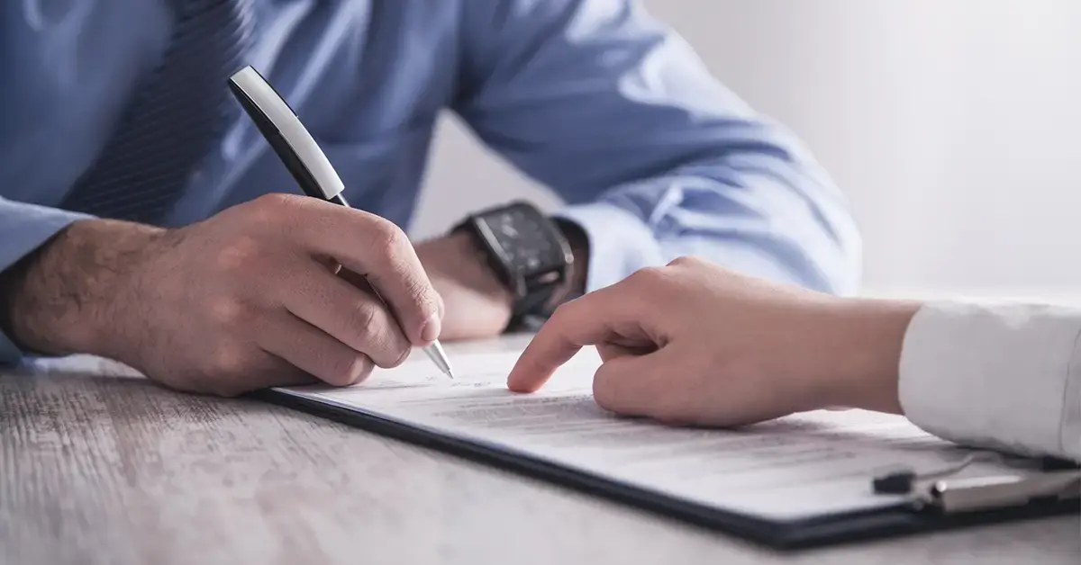 an image of two individuals reviewing and signing a managed it services contract